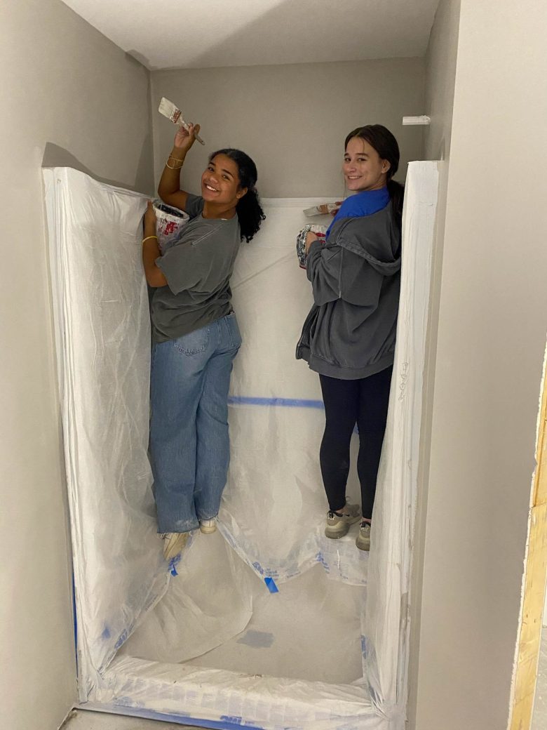 Two students painting above showever