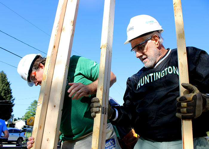 Two men holding up a wall