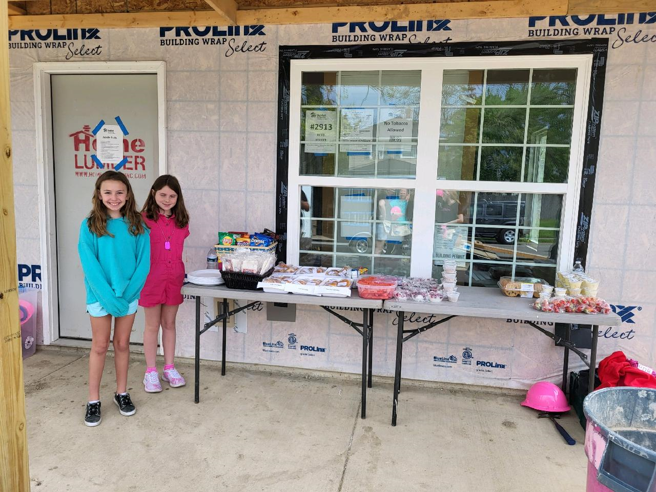 Two girls next to lunch donation