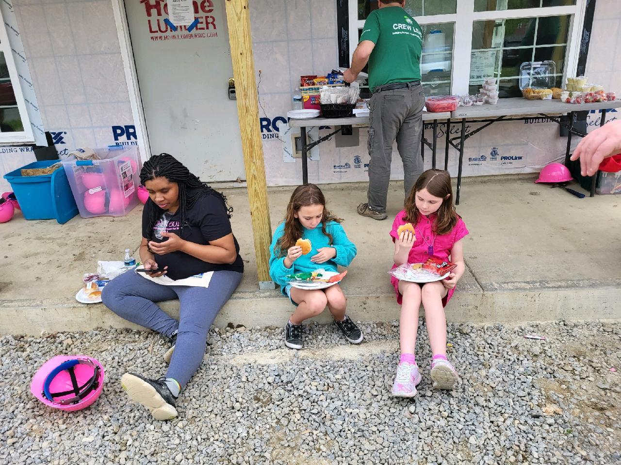 Partner Family and two girls eating lunch on build site