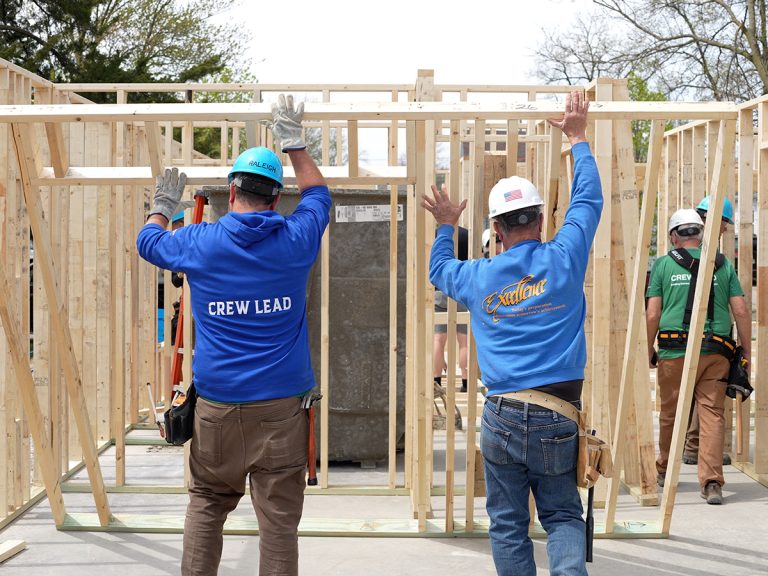 Crew leads raising wall on construction site