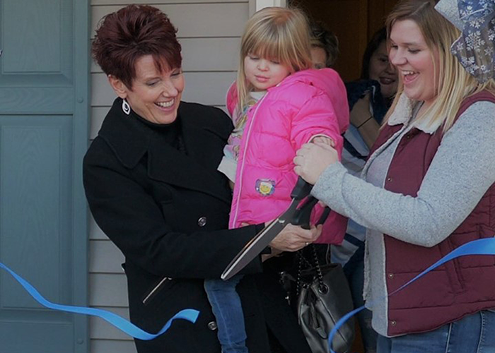 Two women and child cutting ribbon