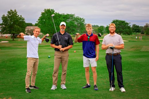Home Lumber group at golf outing posing with golf clubs