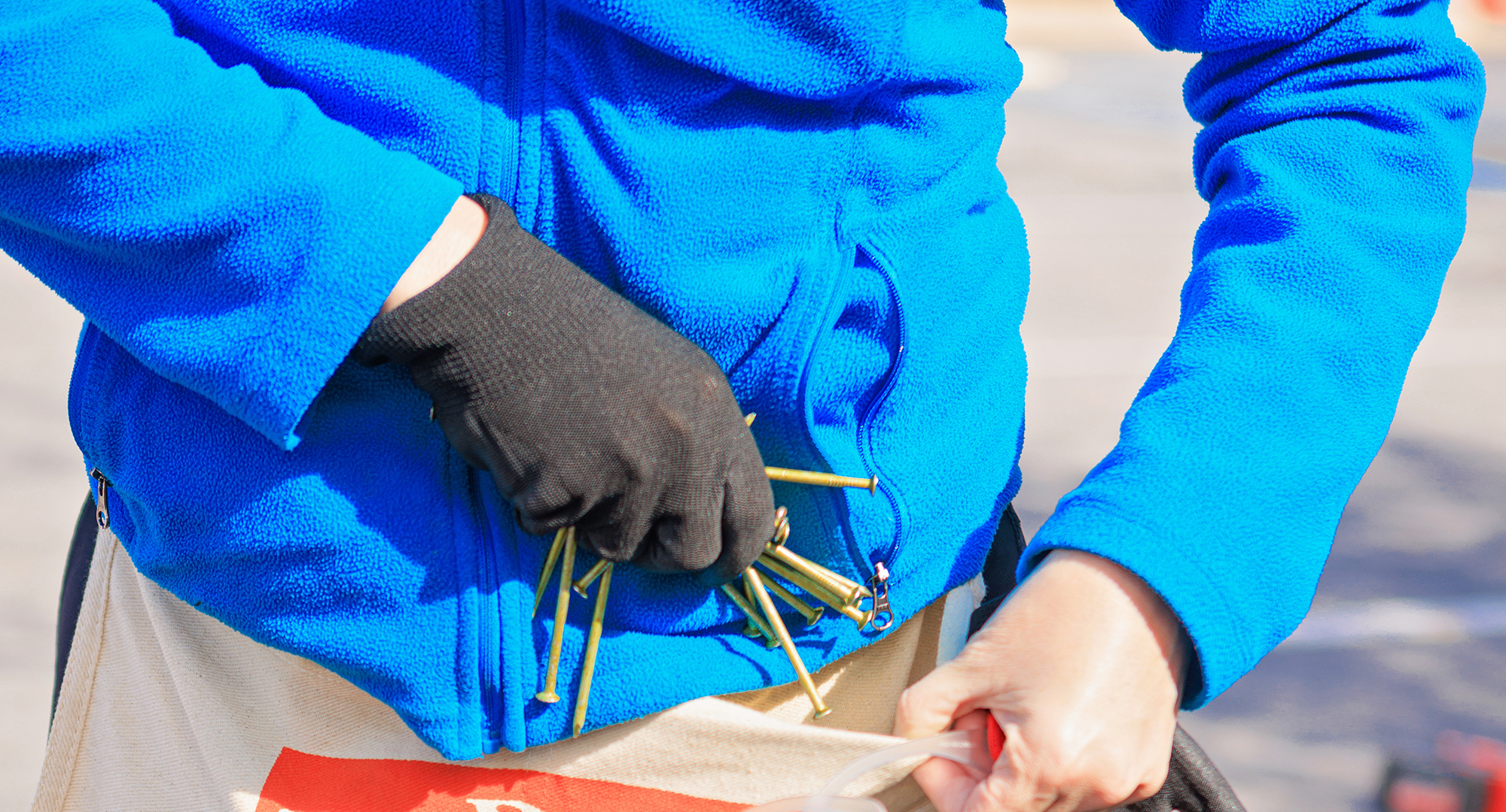 Volunteer placing nails in apron