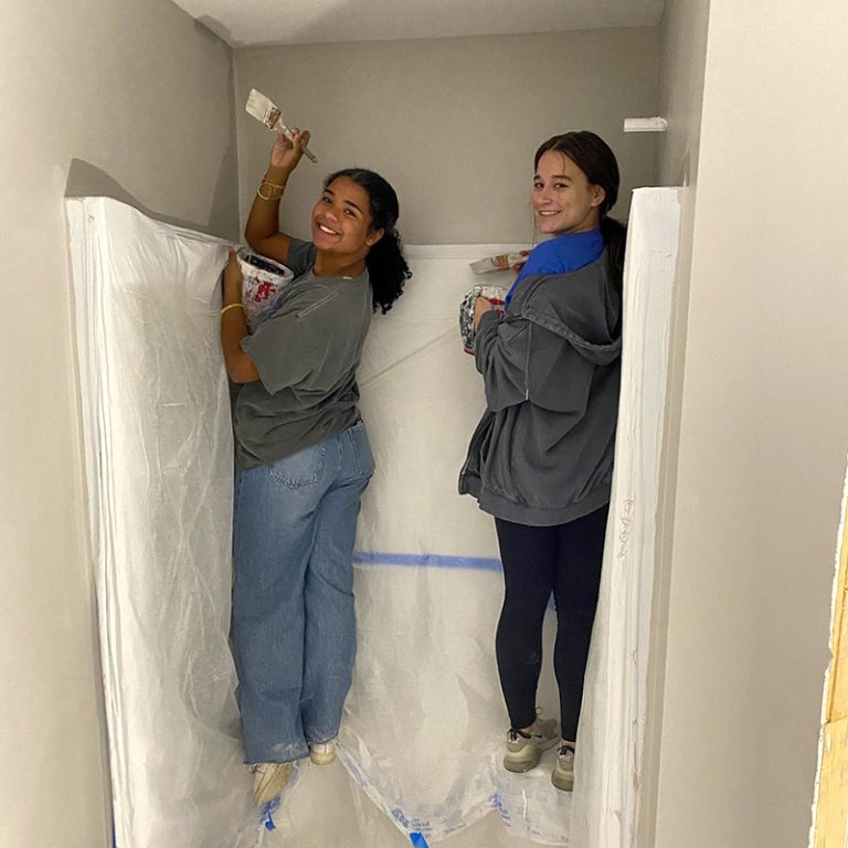 Two volunteers painting bathroom