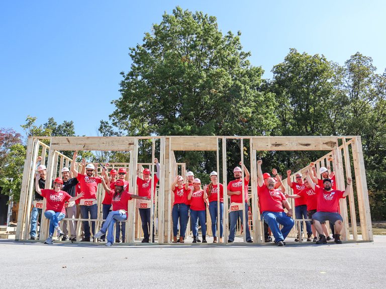 Group of volunteers in front of house walls