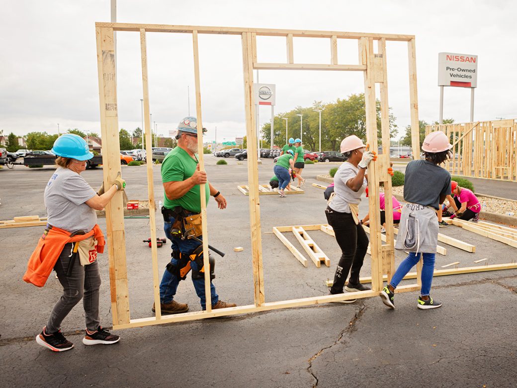Crew Lead helping volunteers carry wall