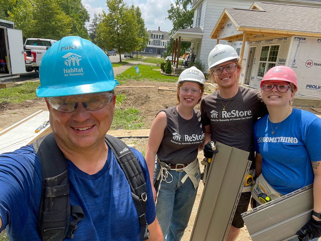 Volunteers holding siding material