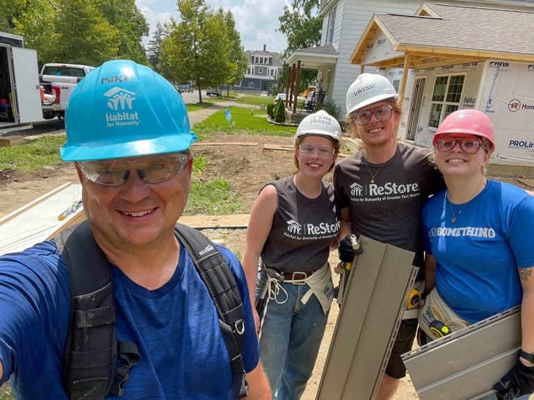Volunteers holding siding material