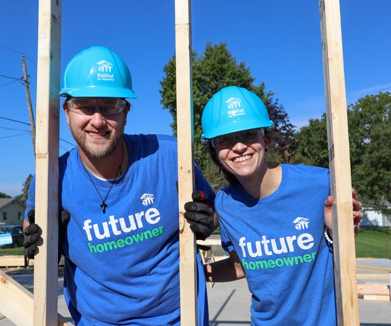 Derek and Shiann behind a freshly built wall of their home