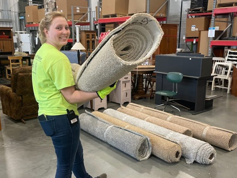 Female carrying roll of carpet