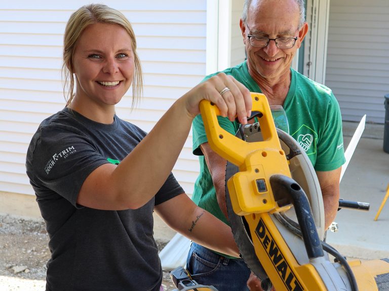 Hailie sawing on job site with crew leads
