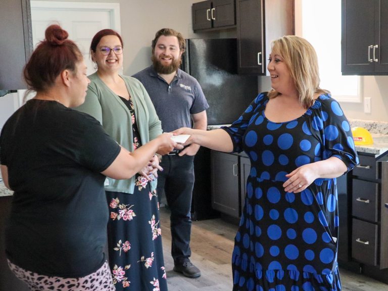 Mara handing ReStore Gift Card to Partner Family